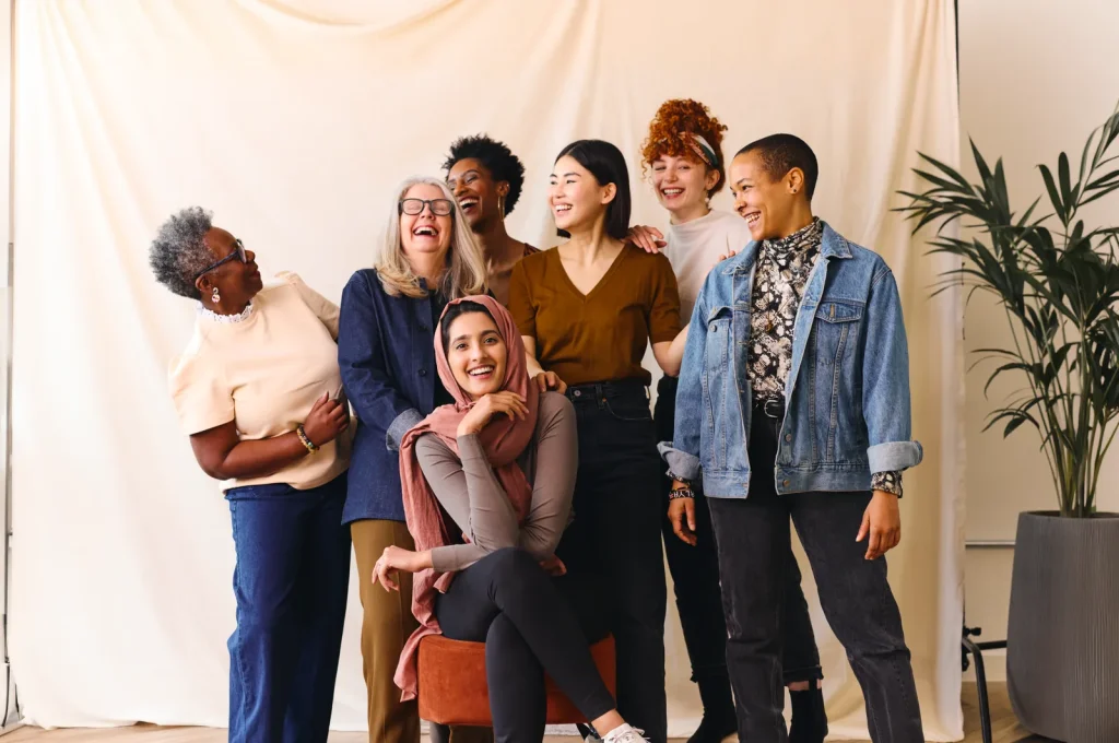 A diverse group of women laughing together in a studio