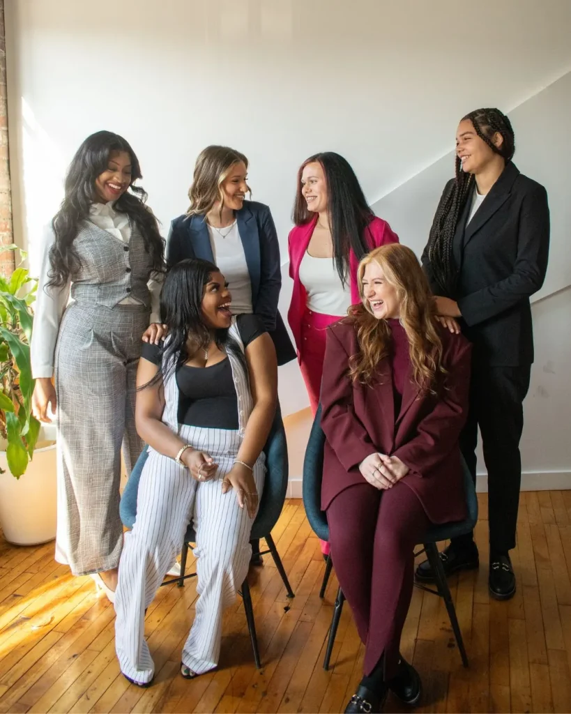 A group of smiling women in office wear gathered together
